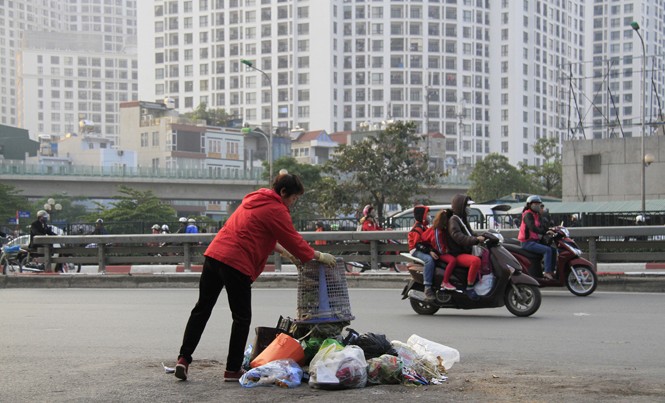 Bí thư Hà Nội: Cấm kinh doanh nếu xả rác bừa bãi Một người phụ nữ thản nhiên đổ rác ra giữa đường Nguyễn Trãi, đoạn gần cầu vượt Ngã tư Sở (Hà Nội). Ảnh: Trường Phong