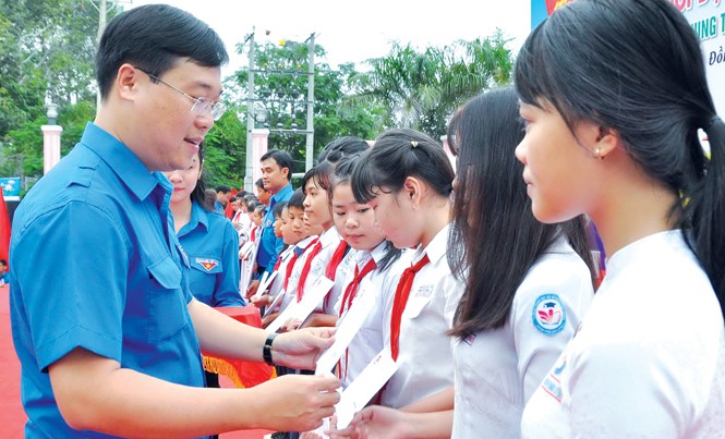 Trải nghiệm để trưởng thành Anh Lê Quốc Phong tặng quà cho học sinh nghèo. Ảnh: Hòa Hội