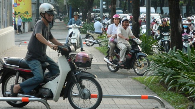 Đề nghị xem lại 'tính pháp lý' lắp barie vỉa hè Sài Gòn Xe máy vẫn luồn lách khá dễ dàng qua barie lắp trên vỉa hè.