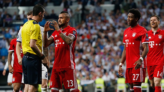 Ba trụ cột Bayern làm loạn phòng thay đồ của trọng tài Vidal (số 23) ám chỉ trọng tài là kẻ cướp, khiến Bayern bị loại tức tưởi vì những quyết định gây tranh cãi. Ảnh: Reuters.