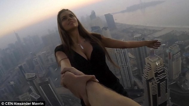 Cô gái bám một tay đu người giữa tòa nhà cao nhất thế giới Viki nắm tay trợ lý đu người trên tòa nhà Cayan Tower, cao 300 mét ở Dubai