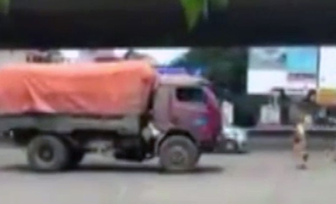 CSGT chạy bộ đuổi theo xe tải lùi ngược chiều Hai CSGT chạy bộ đuổi theo xe tải lùi ngược chiều. Ảnh cắt từ clip.