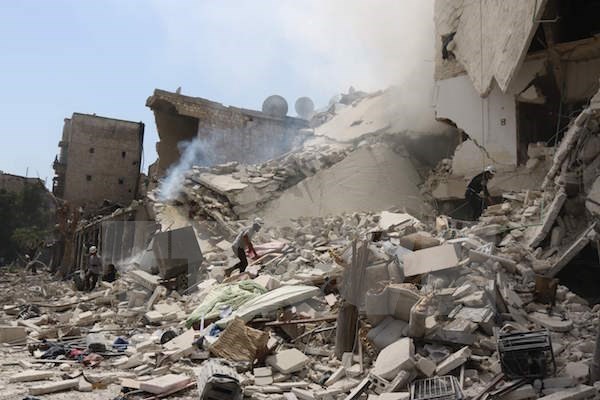 Bản tin 14H: Nga - Mỹ có thỏa thuận ngầm tránh xung đột tại Syria Nhân viên cứu hộ Syria tìm kiếm nạn nhân dưới những đống đổ nát sau vụ không kích tại Aleppo. (Nguồn: AFP/TTXVN)