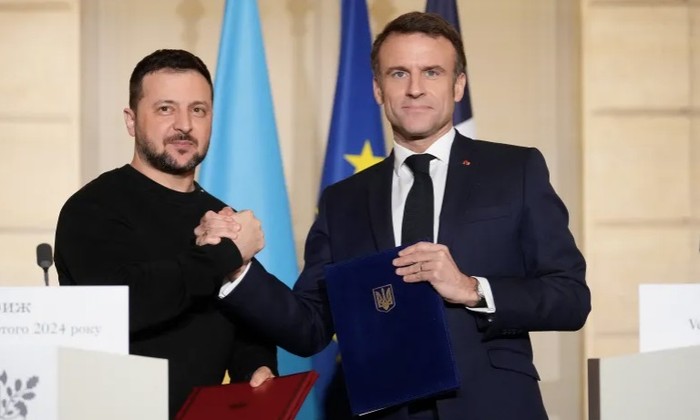 Tổng thống Pháp Emmanuel Macron và người đồng cấp Ukraine Volodymir Zelensky khi ký thỏa thuận an ninh tại Paris. (Ảnh: Reuters)