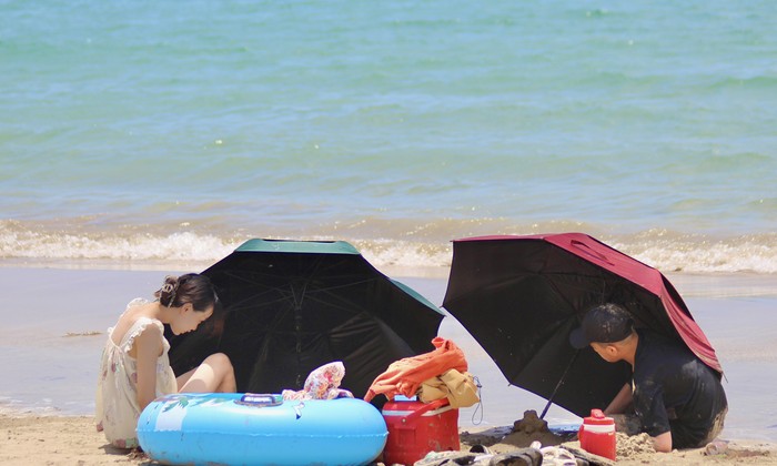 Du khách bịt mặt, che ô tắm biển giữa trưa nắng 40 độ C