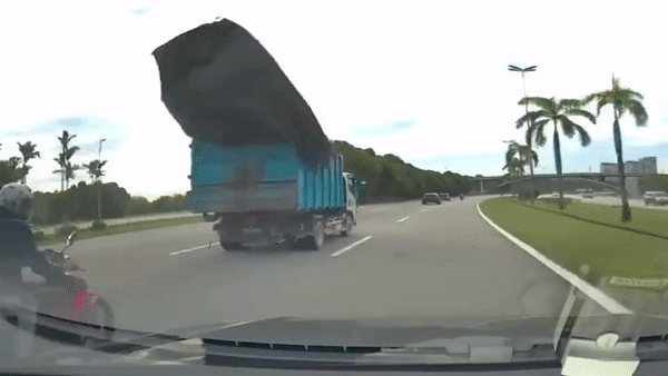 Xe máy loạng choạng do bạt văng từ xe tải
