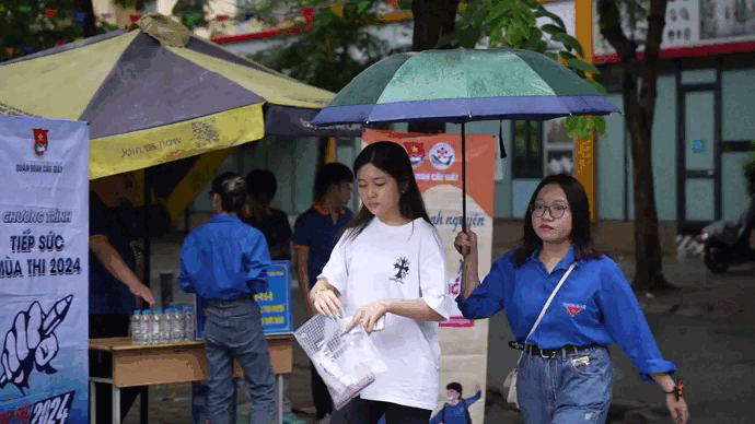 Thanh niên tình nguyện tiếp nước, đội mưa đưa thí sinh vào tận phòng thi