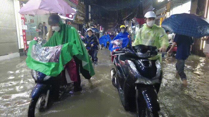 Hà Nội mưa lớn cuối tuần, nhiều tuyến phố ngập sâu, người dân lội nước dắt xe về nhà