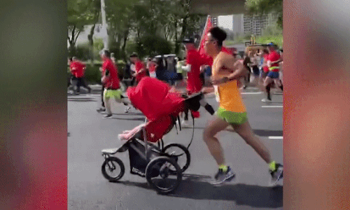 Dân mạng phát &apos;sốt&apos; với hình ảnh người cha đẩy xe đưa con gái nhỏ chạy marathon cùng