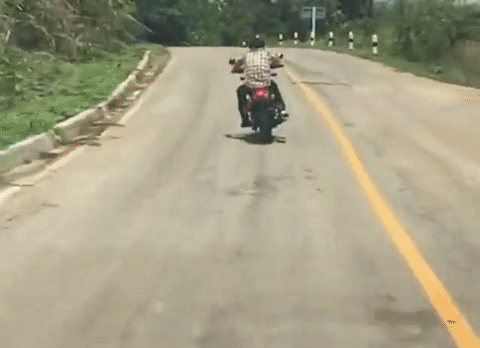Khoảnh khắc người đàn ông bất ngờ bị rắn tấn công khi đang đi xe máy.