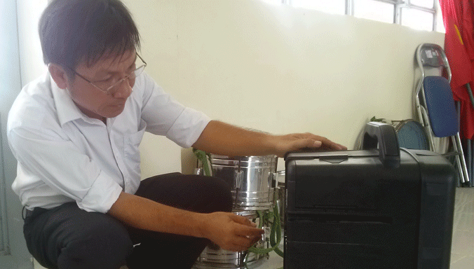 Ông Phi đưa đĩa vào bộ âm thanh di động. Ảnh: Hà Vy.