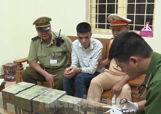 Dùng ô tô hạng sang vận chuyển 35 bánh heroin trị giá 7 tỷ đồng Đối tượng Dần (áo trắng, ngồi giữa) cùng tang vật bị bắt tại khu vực Trạm kiểm soát LN Dốc Quýt. Ảnh: H.S