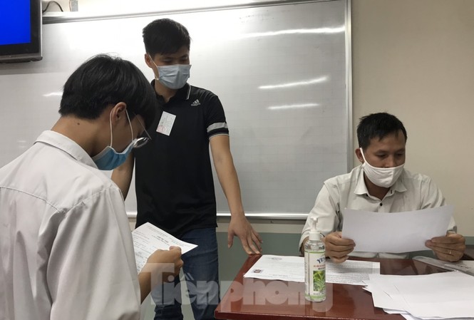 Sau cơn mưa nặng hạt, thí sinh TPHCM làm thủ tục dự thi tốt nghiệp THPT Giám thị coi thi và thí sinh kiểm tra thông tin dự thi tại điểm thi trường THPT Lê Qúy Đôn, quận 3