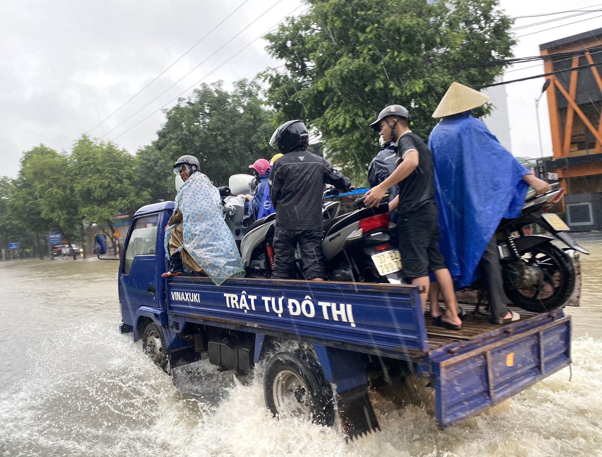 Đường ngập sâu, dân bì bõm mang thùng xốp làm thuyền kéo đồ trên phố ảnh 4