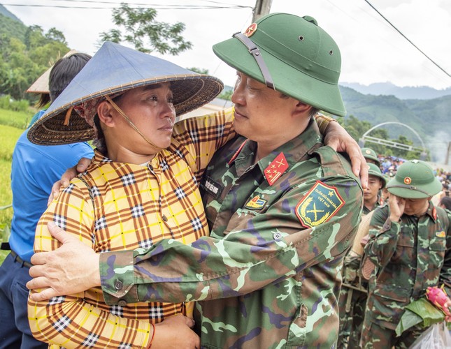 Bà Chiêu Thị Thành khóc và ôm chia tay Đại tá Nguyễn Tiến Dung, Phó Chính ủy Sư đoàn 316. Ảnh: Lê Văn Chương.