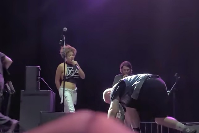 The female singer urinated on the male fan's face right on stage, shocking photo 1