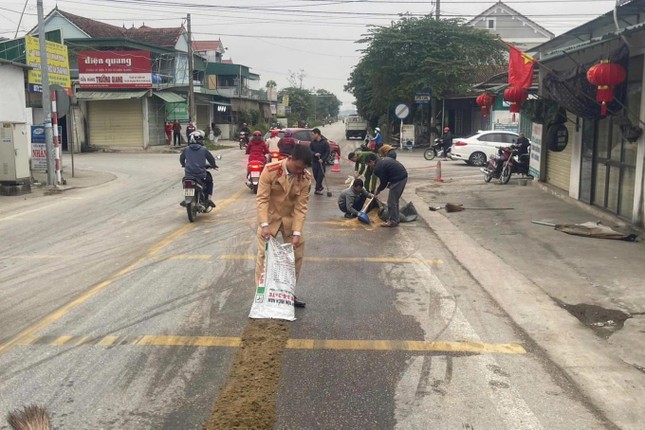 Cảnh sát giao thông rải vỏ trấu, xúc cát xử lý dầu loang trên quốc lộ ảnh 2