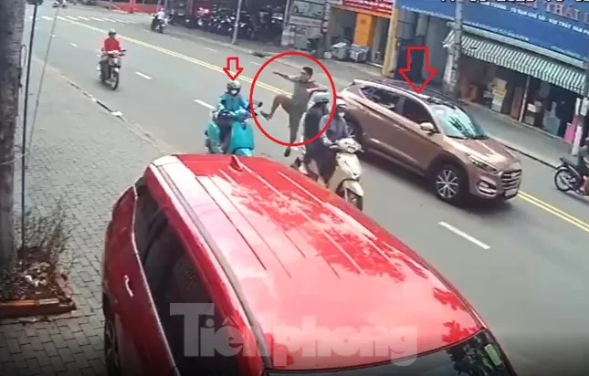 [CLIP] Tài xế dừng ô tô đột ngột giữa đường rồi đạp cô gái đang chạy xe máy ngã nhào ảnh 1