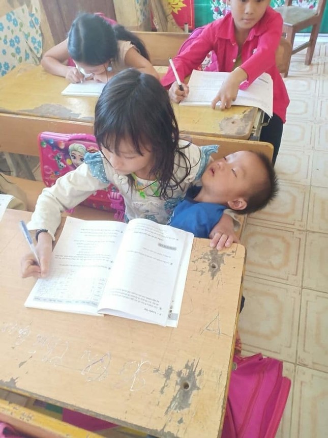 Dân mạng xót xa với hình ảnh bé gái vùng cao vừa viết bài vừa bế em ngủ say trên tay ảnh 1