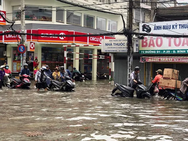 Người dân Sài Gòn di chuyển vất vả trên những con đường ngập đầy nước sau trận bão ảnh 3