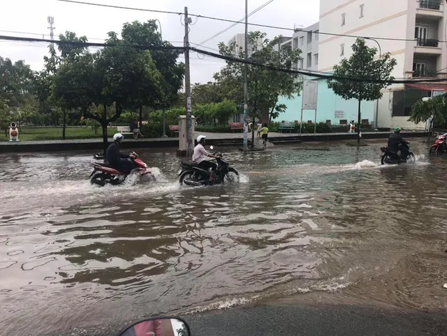 Người dân Sài Gòn di chuyển vất vả trên những con đường ngập đầy nước sau trận bão ảnh 5