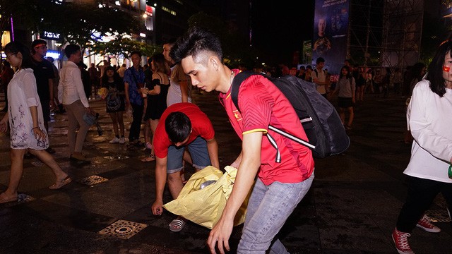 TP.HCM: Đáng yêu hình ảnh bạn trẻ dọn rác trên phố sau trận Việt Nam - Philippines ảnh 1