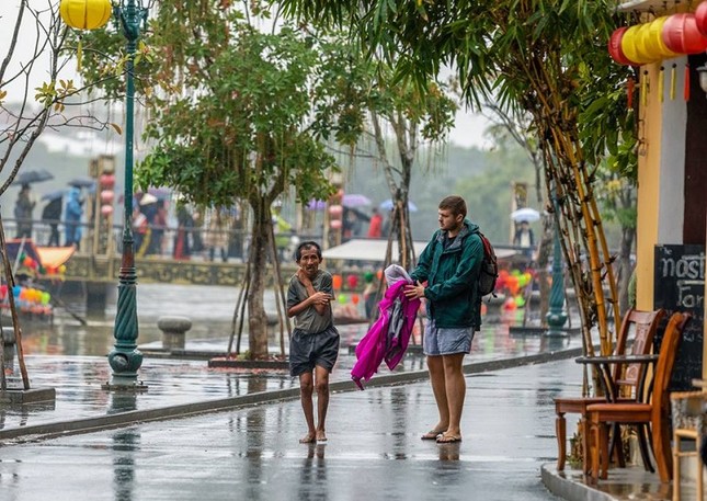 Khoảnh khắc gây "bão" MXH: Chàng trai nước ngoài cởi áo tặng cụ ông ăn xin giữa trời mưa giá rét ảnh 1