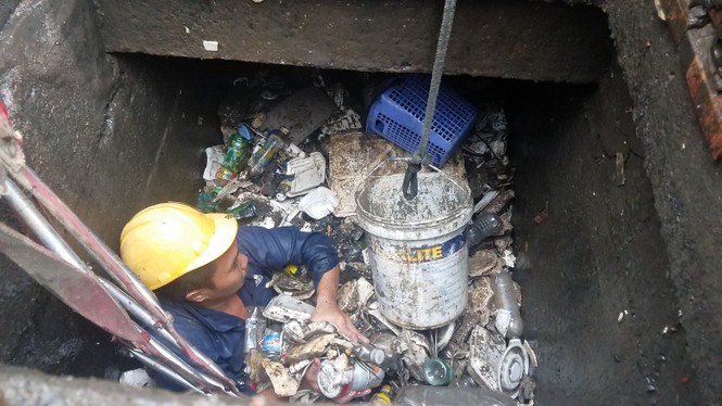 Công nhân ngâm mình dưới cống ở 'rốn ngập' Sài Gòn vớt rác - ảnh 1