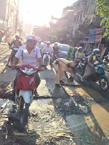 Chiến sĩ cảnh sát xúc cát san lấp ổ gà giữa trời nắng - ảnh 2