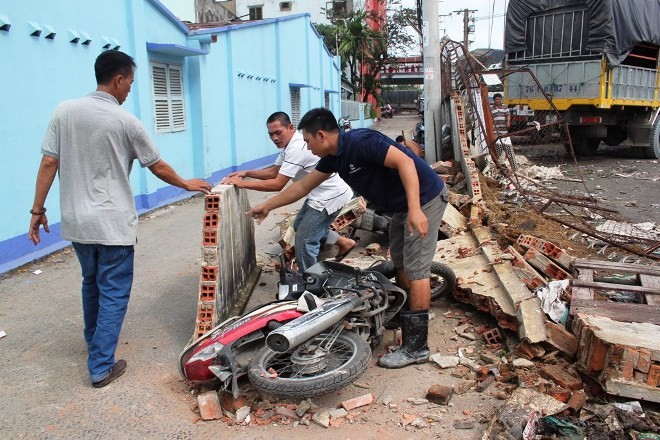 Xe khách lùi sập tường, đè hai xe máy - ảnh 1