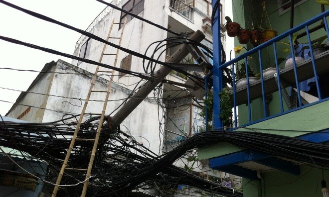 Trụ điện bất ngờ gãy ngang, đổ đè vào nhà dân - ảnh 1