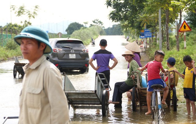 Kiếm bộn từ dịch vụ 'cõng' xe máy qua đường ngập ở Hà Nội - ảnh 4