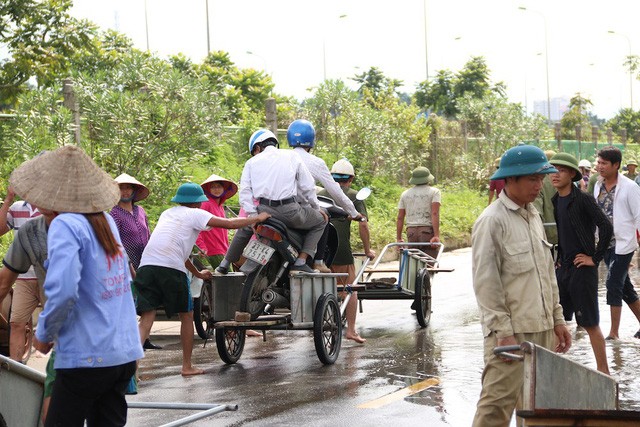 Kiếm bộn từ dịch vụ 'cõng' xe máy qua đường ngập ở Hà Nội - ảnh 2