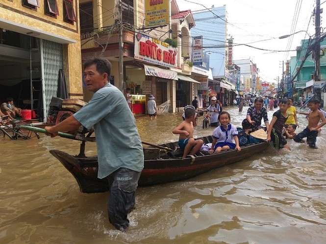 Nước bủa vây, phụ huynh bơi ghe trên phố đón con - ảnh 1