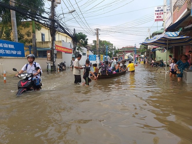 Nước bủa vây, phụ huynh bơi ghe trên phố đón con - ảnh 2