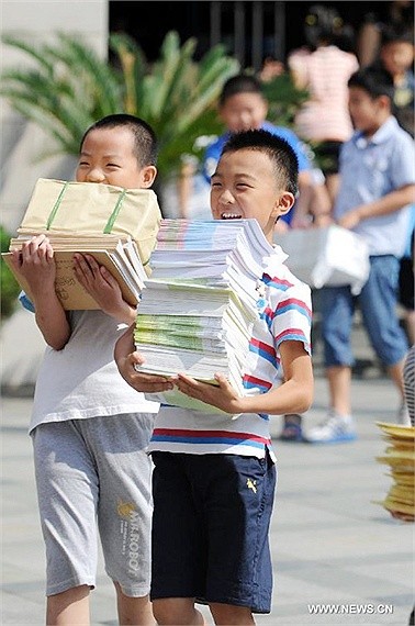 Tân học sinh trường thực nghiệm Baochuta ở Hàng Châu, thủ phủ của tỉnh Chiết Giang , phía đông Trung Quốc ôm trên tay ôm chồng sách giáo khoa mới với nụ cười rạng rỡ ngày khai giảng 1/9