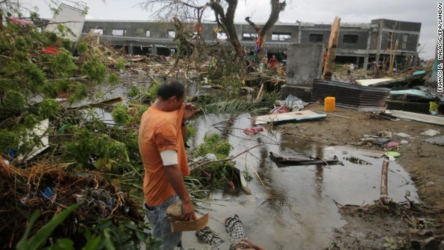 Dưới chân người đàn ông này là thi thể của một người dân khu vực. Những người Philippines dường như không thể khóc nổi bởi đã có quá nhiều người thiệt mạng do bão Haiyan
