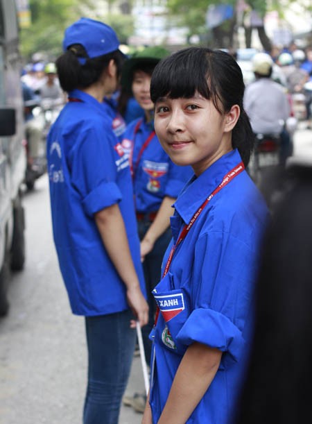 Các nữ tình nguyện viên trường ĐH Ngoại Thương Hà Nội phân luồng giao thông trước cổng trường thuộc phố Chùa Láng