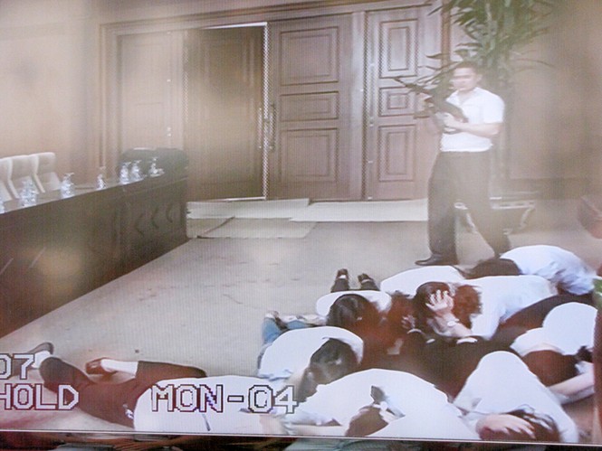 Sau đó, một tên bên ngoài cảnh giới, 4 tên xông vào khống chế ngân hàng, yêu cầu thủ quỹ mở két đưa tiền, vàng. Khi nghe súng nổ, thủ quỹ đã kịp thời ấn nút hệ thống chuông báo động kết nối trực tiếp với lực lượng công an sở tại