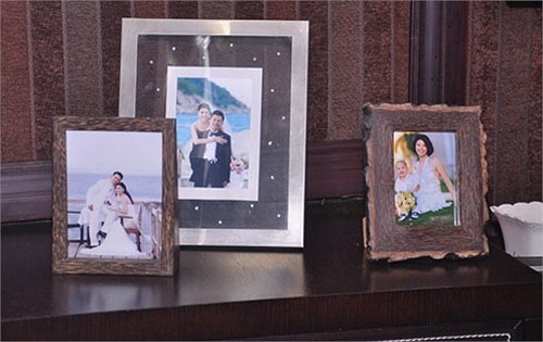 Trên chiếc bàn nhỏ trong phòng có những bức hình là dấu mốc hạnh phúc trong cuộc sống riêng của hai vợ chồng hoa hậu.