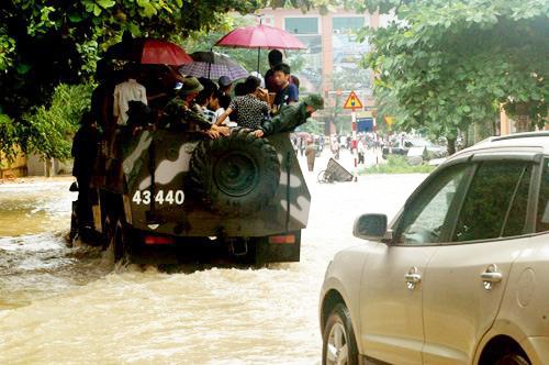 Mưa lũ quá to khiến nhiều thí sinh ở Thái Nguyên không thể đến trường làm thủ tục thi đại học đợt 1 vào tháng 7. Trước tình hình đó, Tỉnh đội Thái Nguyên, Quân khu I đã quyết định điều động xe bọc thép của quân đội đưa các thí sinh đến làm thủ tục đúng giờ. Hình ảnh các chiến sĩ quân đội đồng hành cùng các sĩ tử khiến nhiều người cảm kích. Ảnh: Đặng Luân