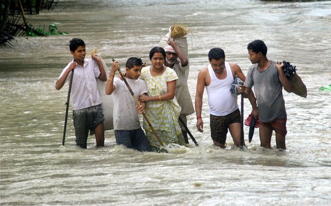 Việc đi lại gặp nhiều khó khăn. Người dân lôi qua nước lũ tại huyện Nalbari, Assam