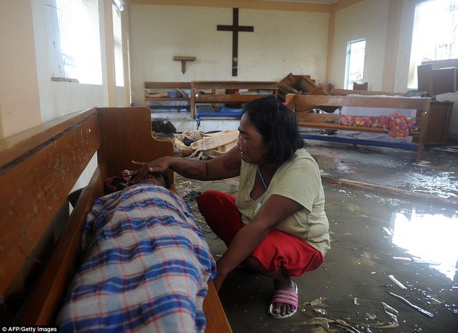 Bà mẹ Philippines ngôi trong một nhà thờ bị tan hoang sau cơn bão, bên cạnh thi thể của người con trai. Bà đã khóc cạn nước mắt vì mất con, mất nhà cửa do bão Haiyan