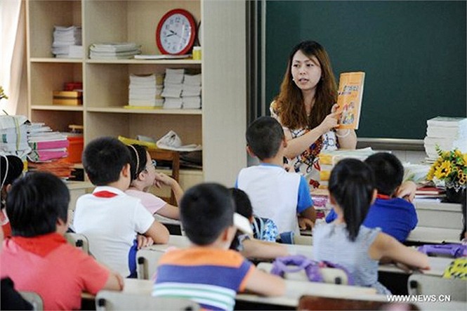 Một giáo viên giới thiệu sách giáo khoa mới cho học sinh tại trường thực nghiệm Baochuta ở Hàng Châu, Chiết Giang, phía Đông Trung Quốc trong ngày khai giảng 1/9