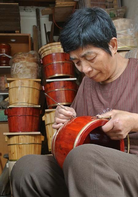 Một phụ nữ làm thùng gỗ- nghề truyền thống của thị trấn