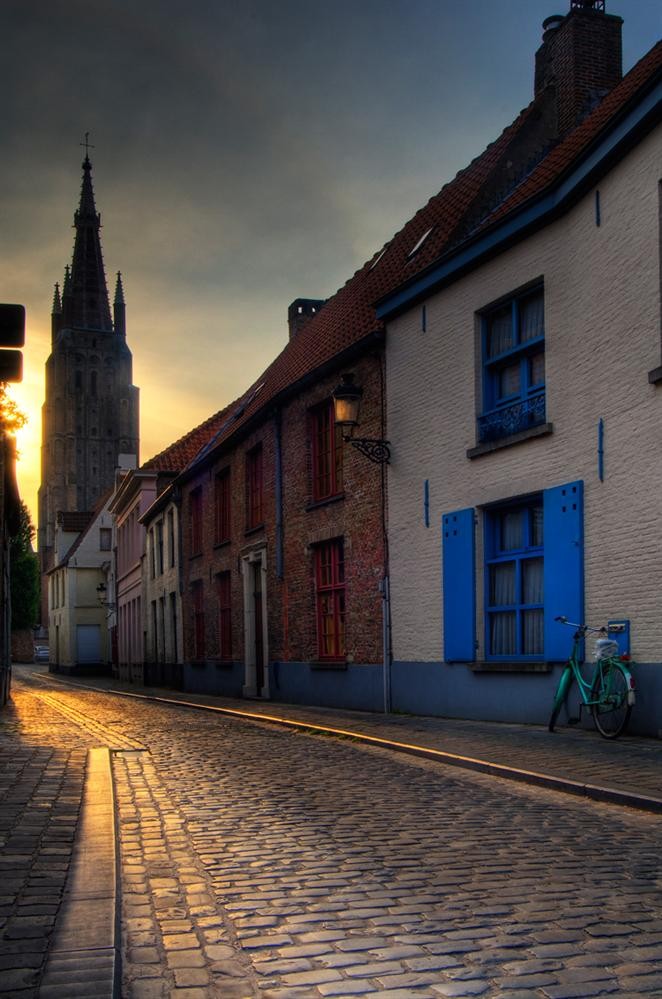 Một con đường cổ ở Bruges với tháp nhà thờ Our Lady thấp thoáng phía xa