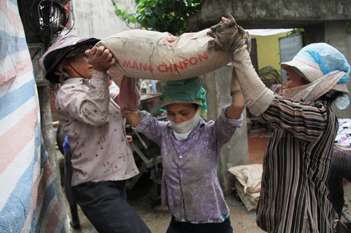 Ngoài ra, các chị còn đội bê tông. Mỗi bao nặng 50kg. Ảnh: Trường Phong
