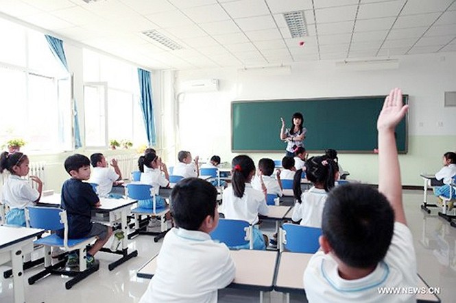 Giáo viên giới thiệu các quy tắc giơ tay trả lời trong lớp học cho tân học sinh tại trường tiểu học Qianbajia, Bắc Kinh