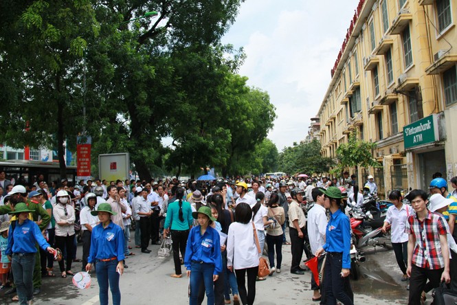 Những nữ sinh viên tình nguyện bảo đảm trật tự giao thông trưa 4 - 7 trước cổng trường Đại học Khoa học Xã hội và Nhân văn Hà Nội. Ảnh: Trường Phong