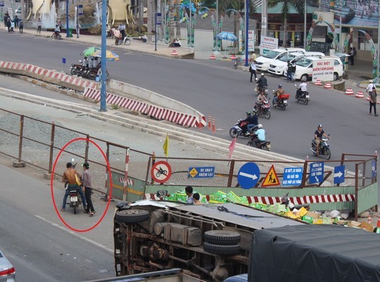 Xe tải lật nghiêng, 2 thanh niên lao vào 'hôi của' - ảnh 2